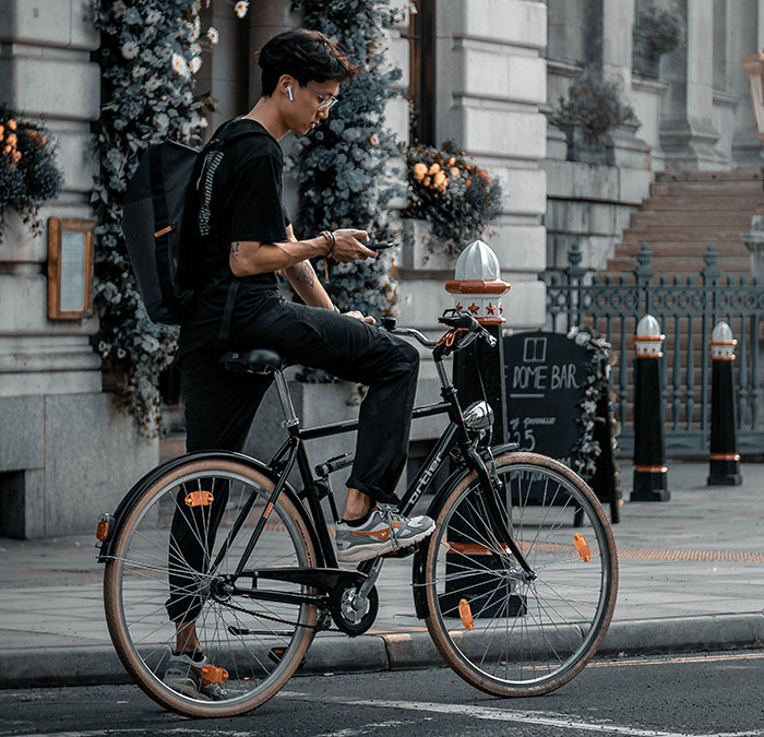 Person looking at phone and holding bike