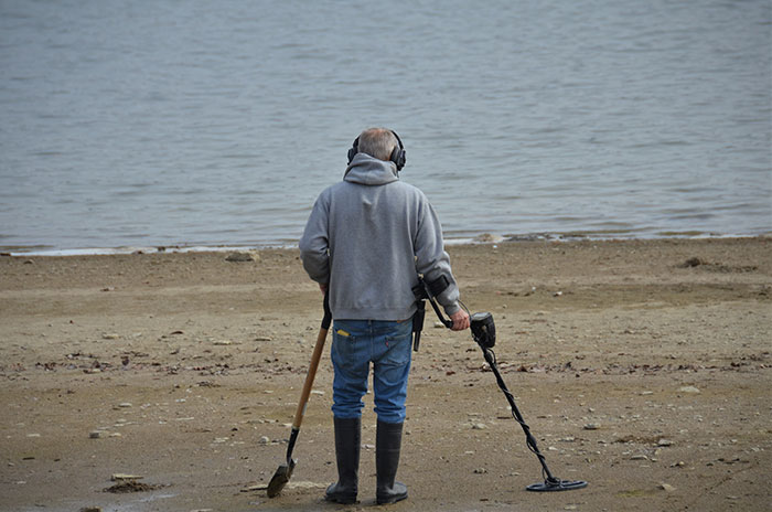 Man using metal detector near the sea