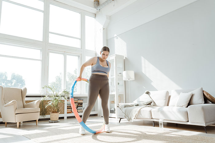 A Woman Using a Hula Hoop in the Living Room