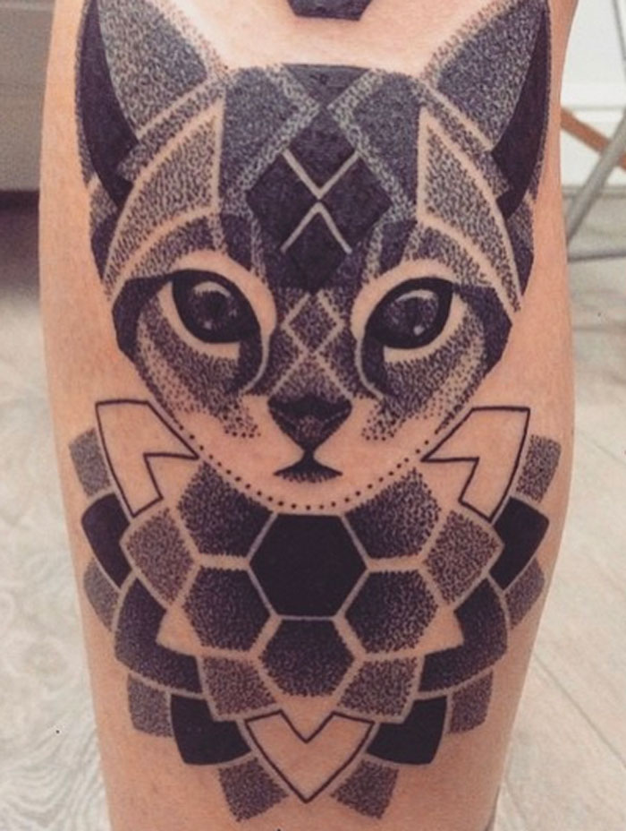 Geometric tattoo of a stylized cat with intricate hexagonal patterns on the skin.