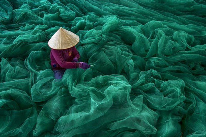 Vietnamese Woman Repairing A Fishing Net. Photo By Danny Yen Sin Wong