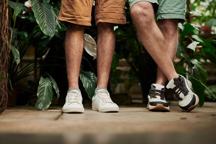 Persons standing and wearing shorts with white and black shoes