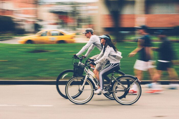 Couple Riding Bicycles In Town 