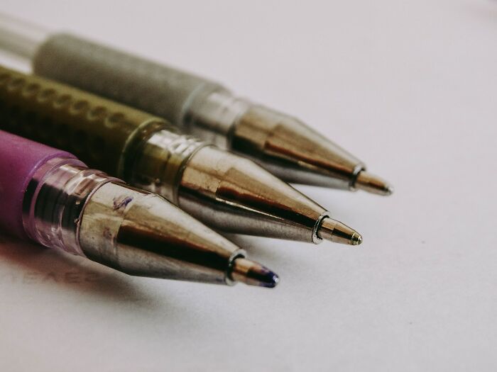 Three Pens Placed On Paper