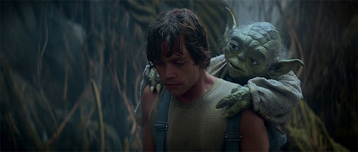 Yoda sitting on Luke Skywalker shoulders