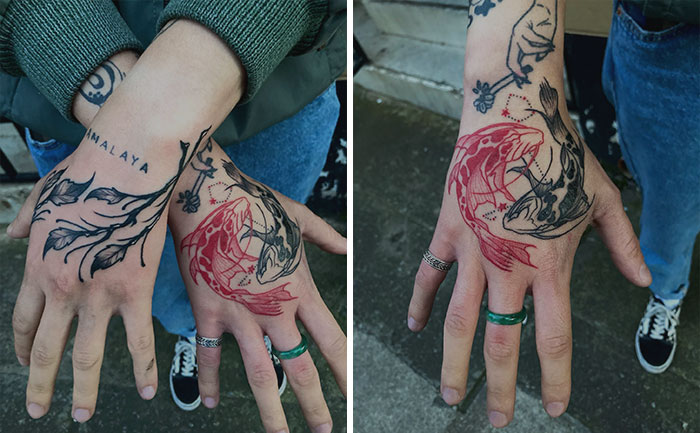 Red ink tattoos featuring koi fish designs on hands with black detailing and jewelry.
