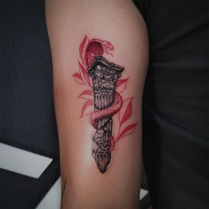 Red snake around the pillar tattoo 
