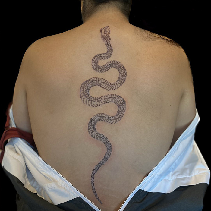 Skeleton snake tattoo on spine