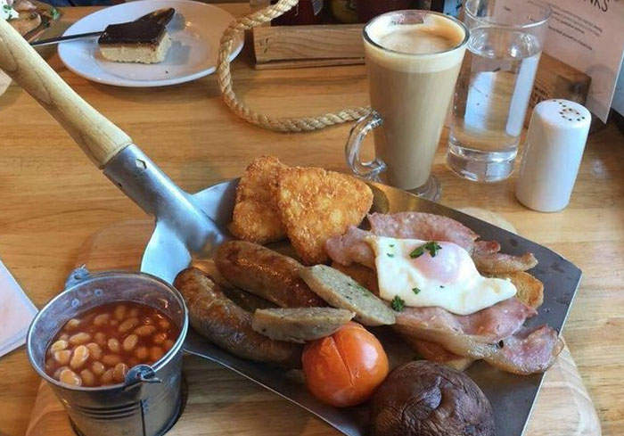 Un desayuno inglés completo servido por un hipster