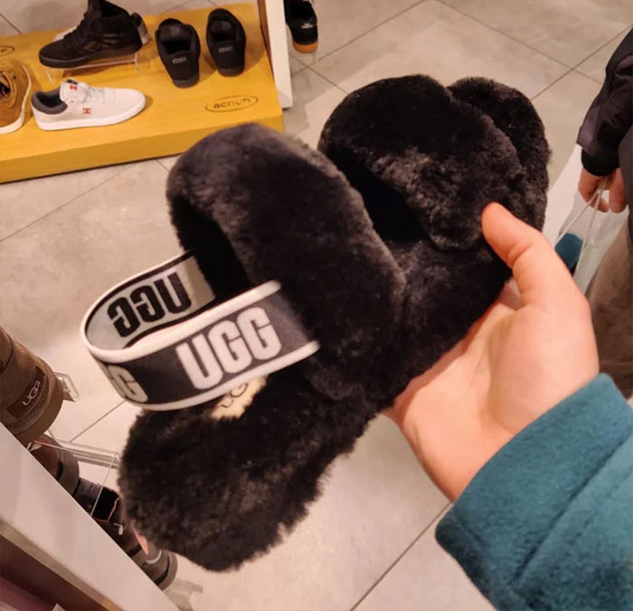 Person holding sandals with a fake fur