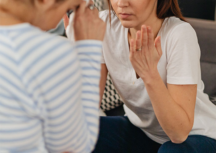 a woman in a white shirt looking at another woman