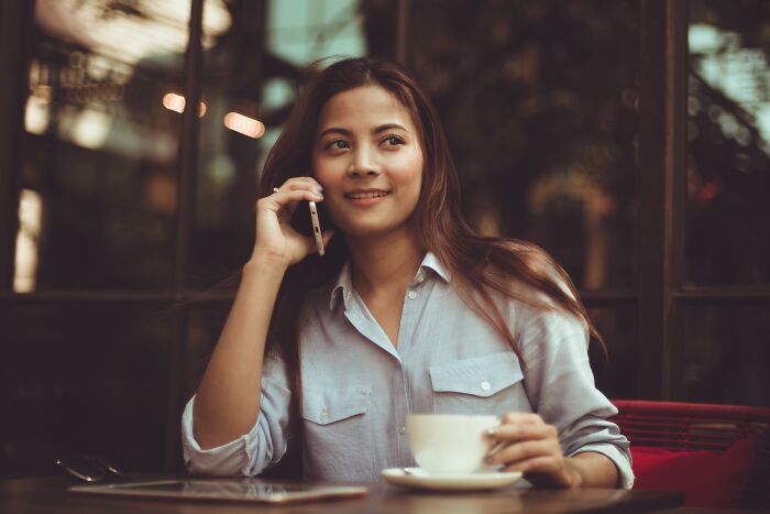 Woman talking on the phone drinking coffee 