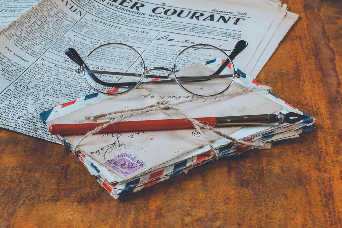 A pair of glasses lying on the pile of letters