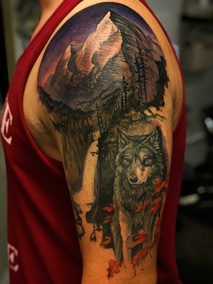 Colorful wolf and mountain arm tattoo 