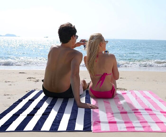 Couple sitting on the beach towels 
