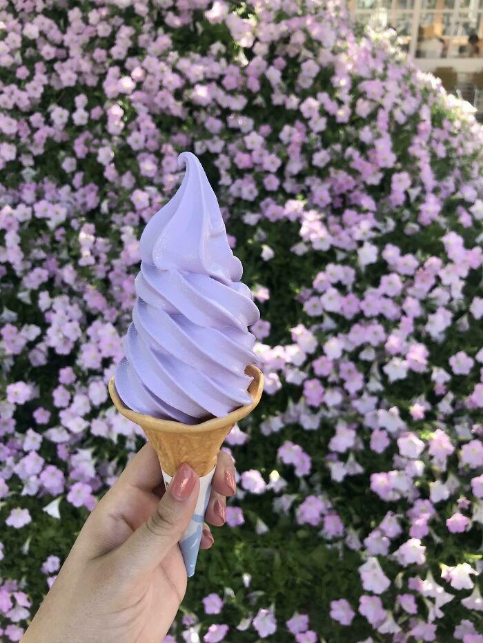 Person holding purple ice cream in the cone 