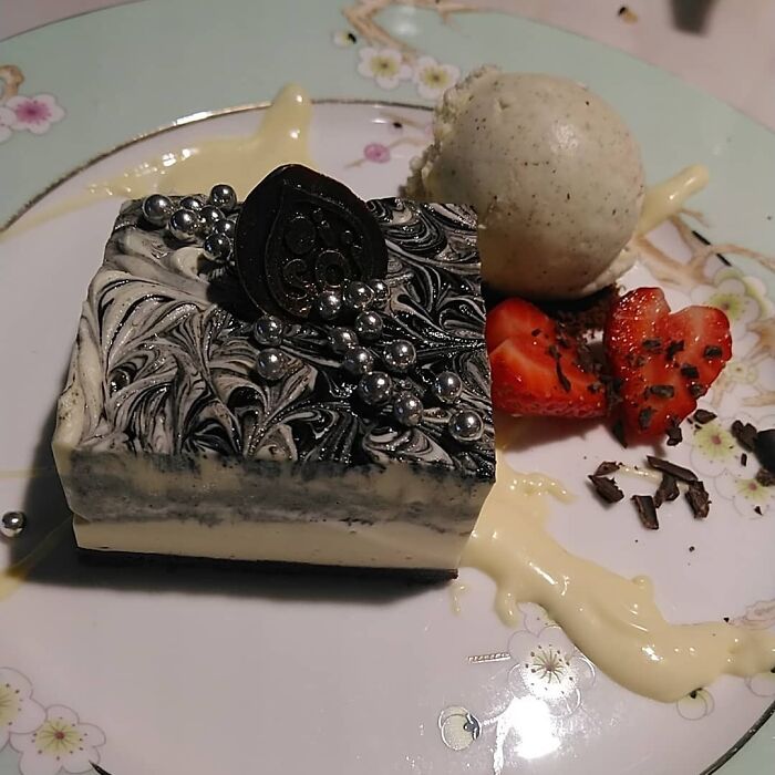 Black and white ice cream on a plate with strawberries 