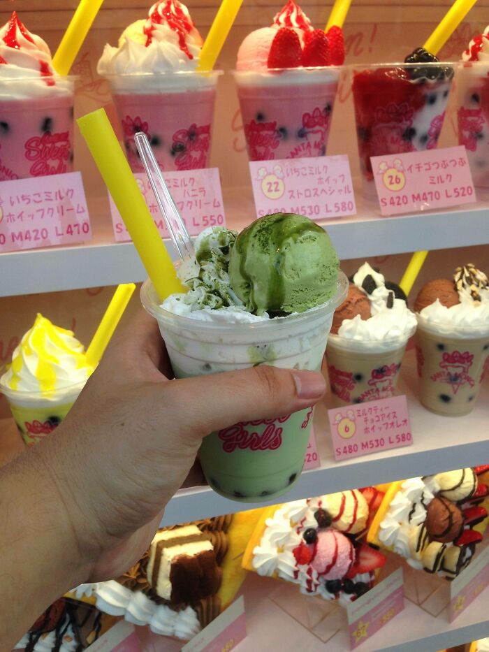 Person holding white and green ice cream in the cup 