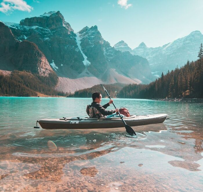 man canoeing near the view of mountains