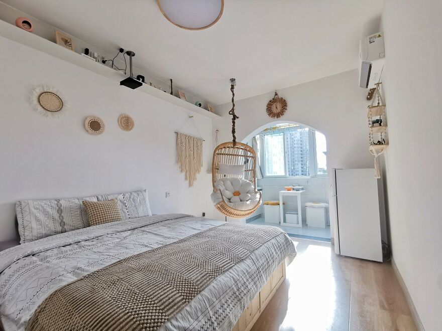 White bedroom with a hanging chair 