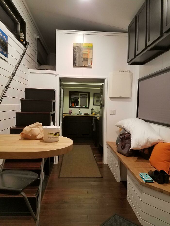 Interior of a cozy tiny house design with a loft, wooden furniture, and modern decor.