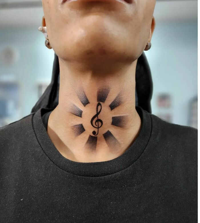 Black treble clef tattoo on neck