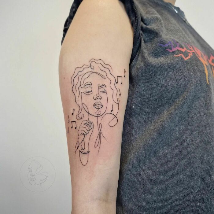 Woman singer one line tattoo on arm