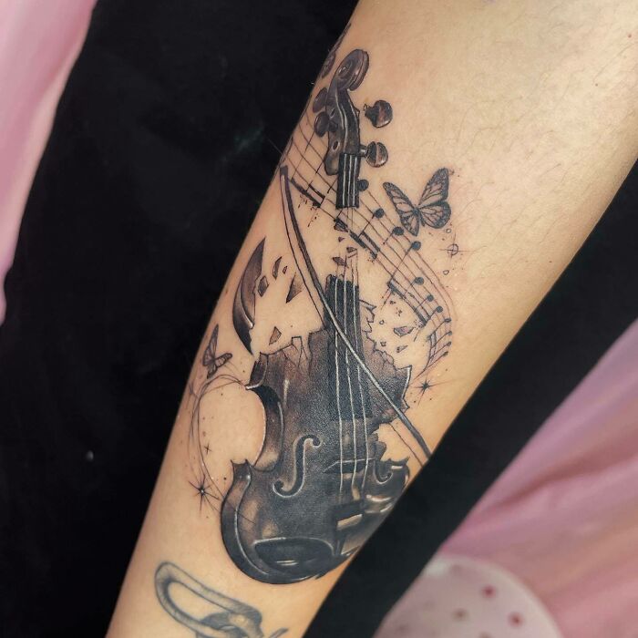 Realistic broken violin tattoo