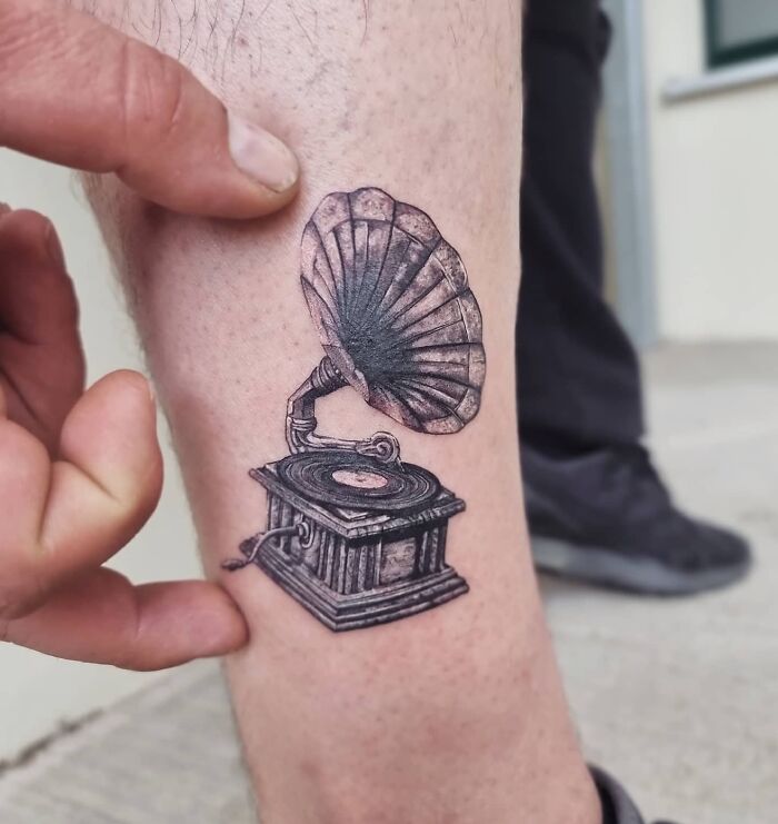 Realistic gramophone tattoo on a leg