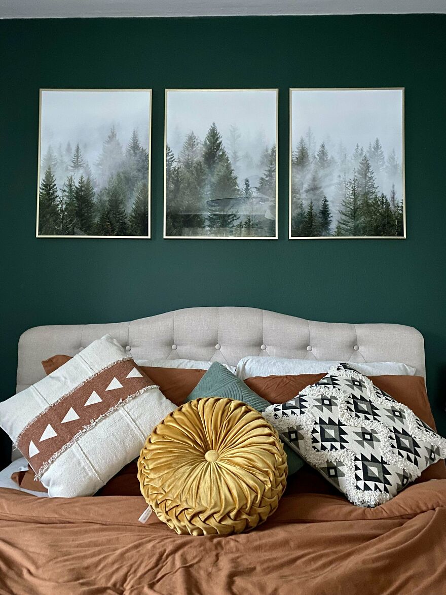 Green bedroom with white bed and images of the woods 
