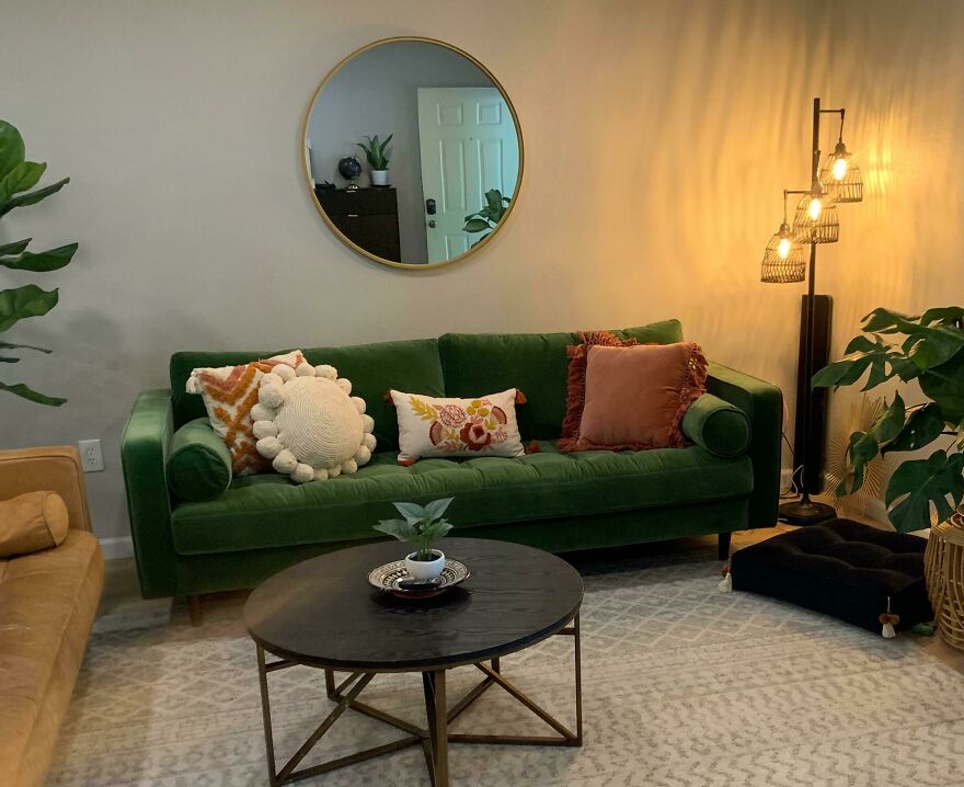 Green couch with pillows next to a lamp