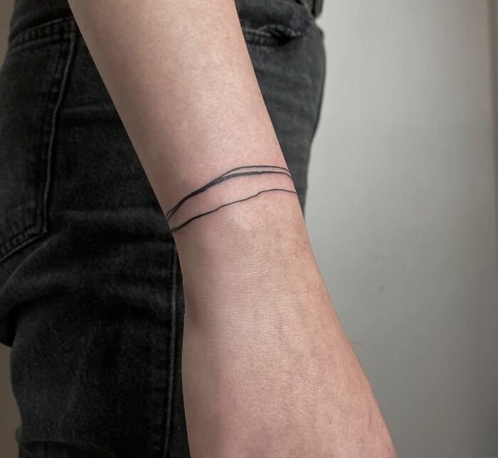 Simple thread around wrist tattoo