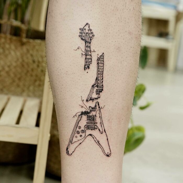 Black crashed guitar leg tattoo