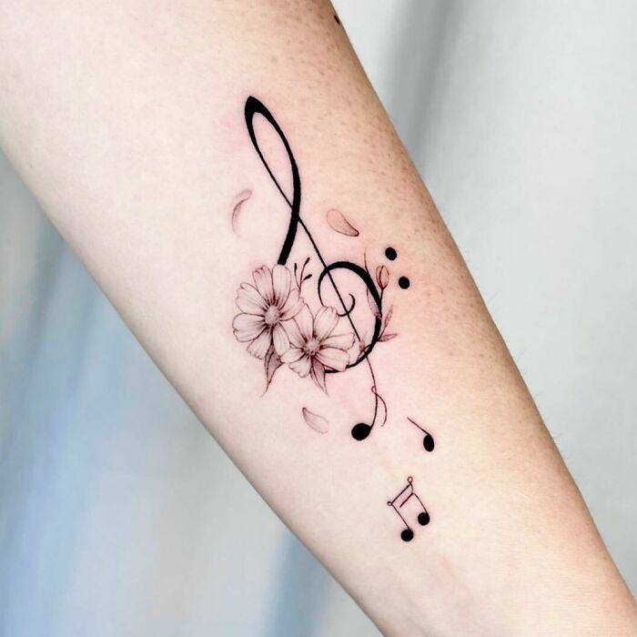Music notes and flowers tattoo