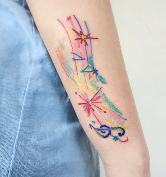 Colorful arm tattoo with notes and stars