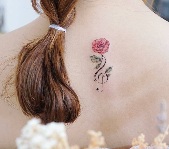 Music note and flower back tattoo