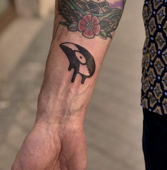 Black melting vinyl record tattoo on arm