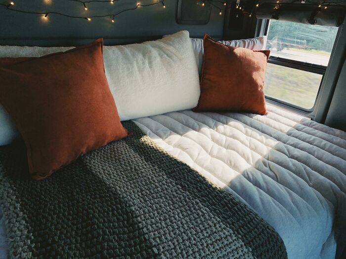 Bed with orange and white pillows 