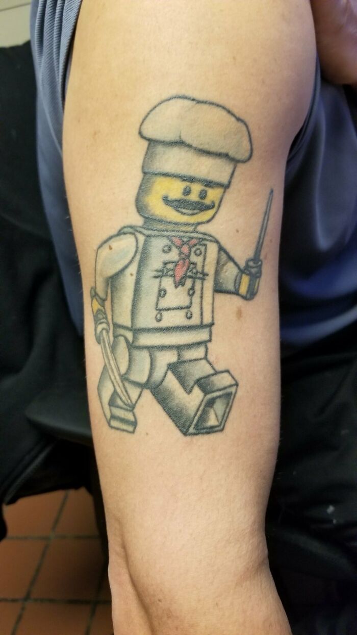 Lego chef tattoo in watercolor style on an arm, showcasing creative food ink-spiration.