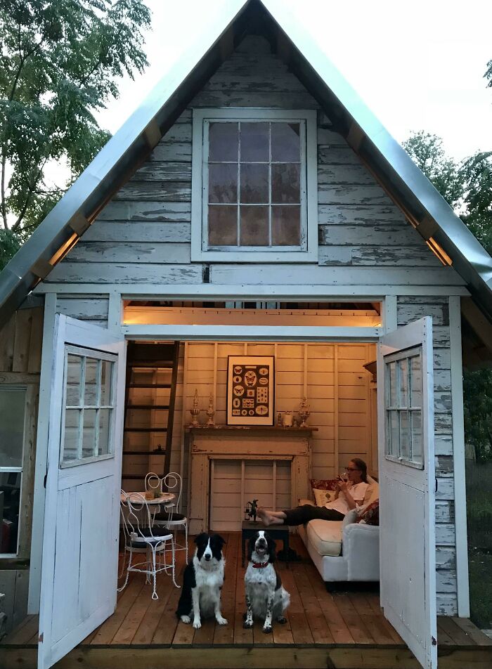 House with opened doors with two dogs and woman on a couch 