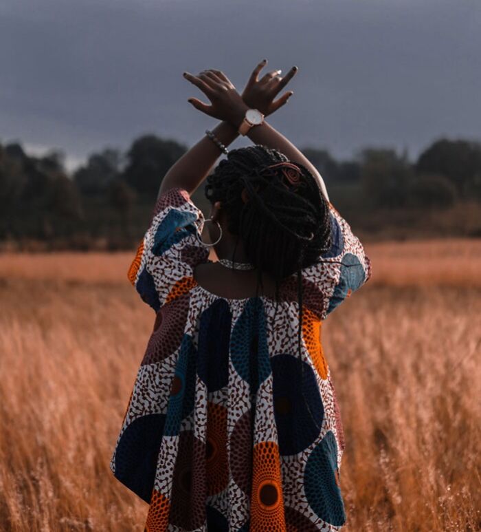 Woman standing in field and wearing colorful shirt