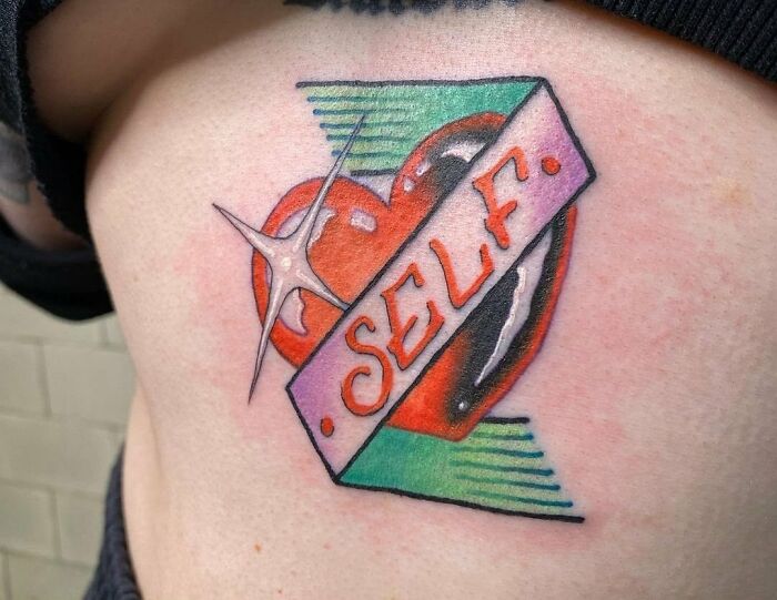 A vibrant self-love tattoo featuring a heart with the word 'SELF' across it, designed to inspire empowerment.