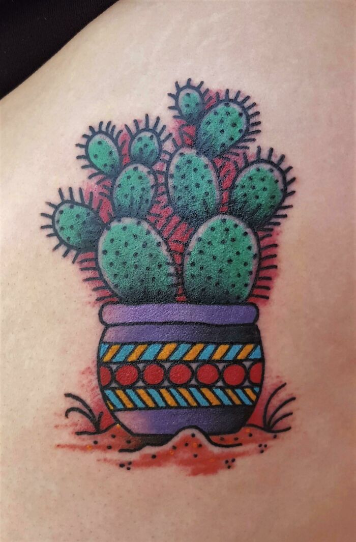 Colorful American traditional cactus tattoo in a patterned pot.