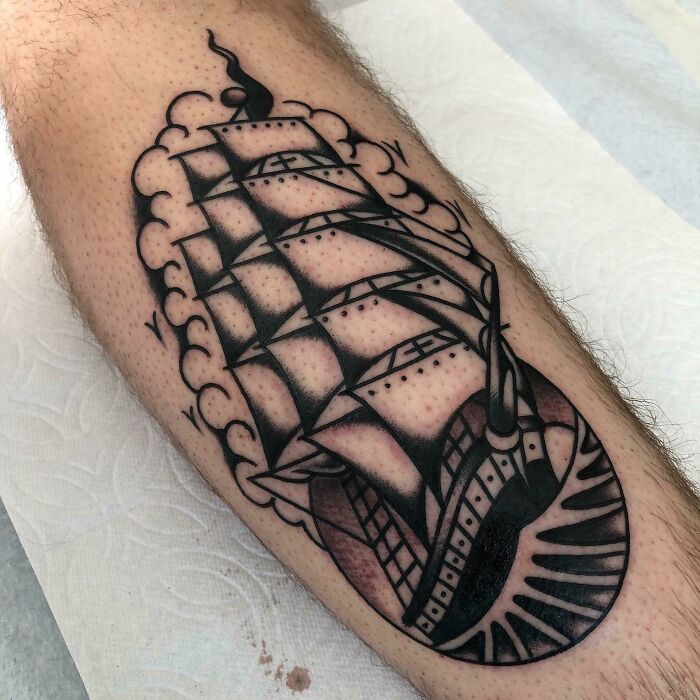 American traditional tattoo of a ship with bold outlines and classic style on an arm.