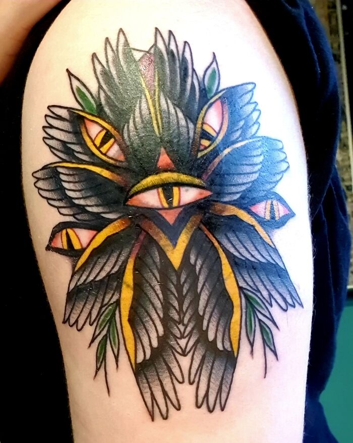 American traditional tattoo with eye and feather design in vibrant colors.