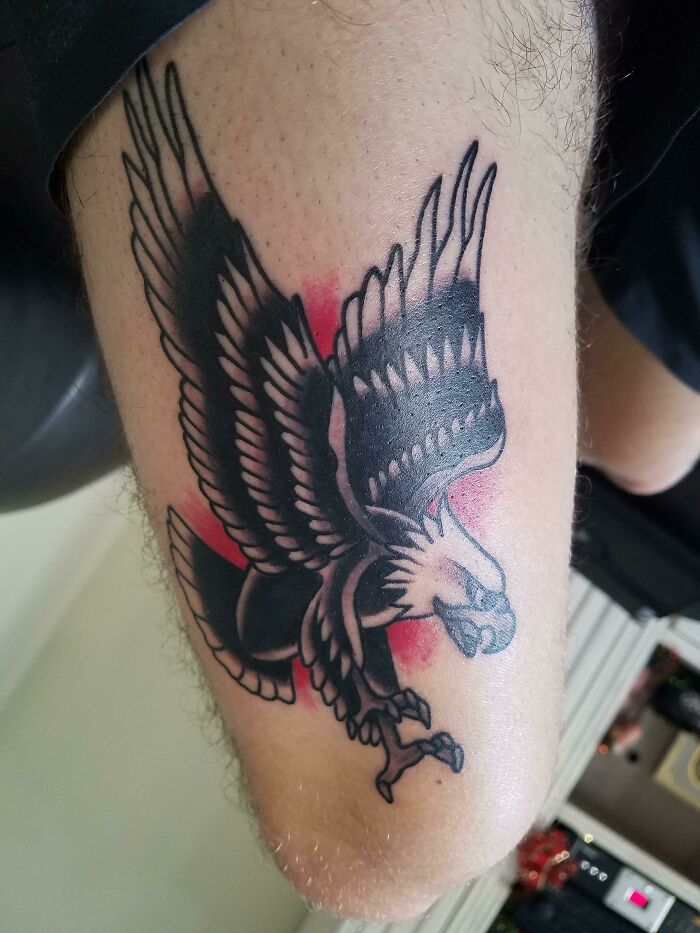 American traditional tattoo of an eagle on an arm, featuring bold lines and vibrant colors.