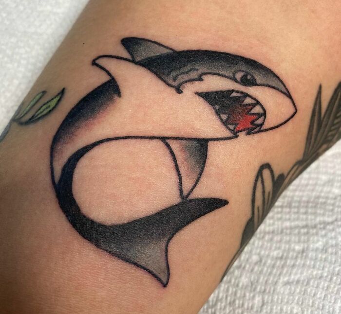 American traditional tattoo of a shark on an arm, featuring bold lines and classic design elements for a timeless look.