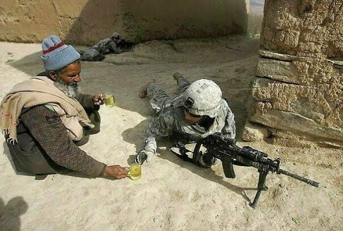 An Afghan Citizen Offering A Cup Of Tea To An U.S. Soldier On The Duty