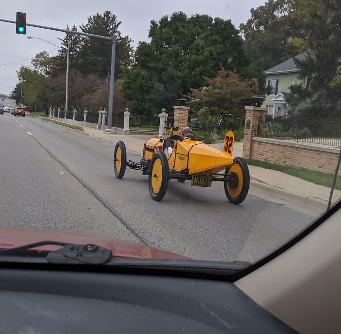 This Guy Driving An Old Style Race Car Around My Town. He Has The Correct Clothes On And Everything
