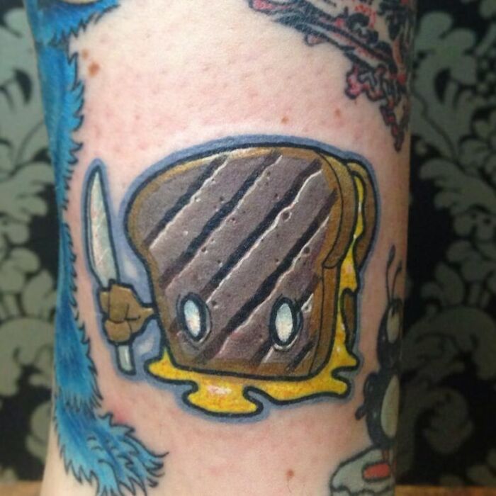 Watercolor tattoo of a bread and cheese sandwich on skin, showcasing creative food ink-spiration.